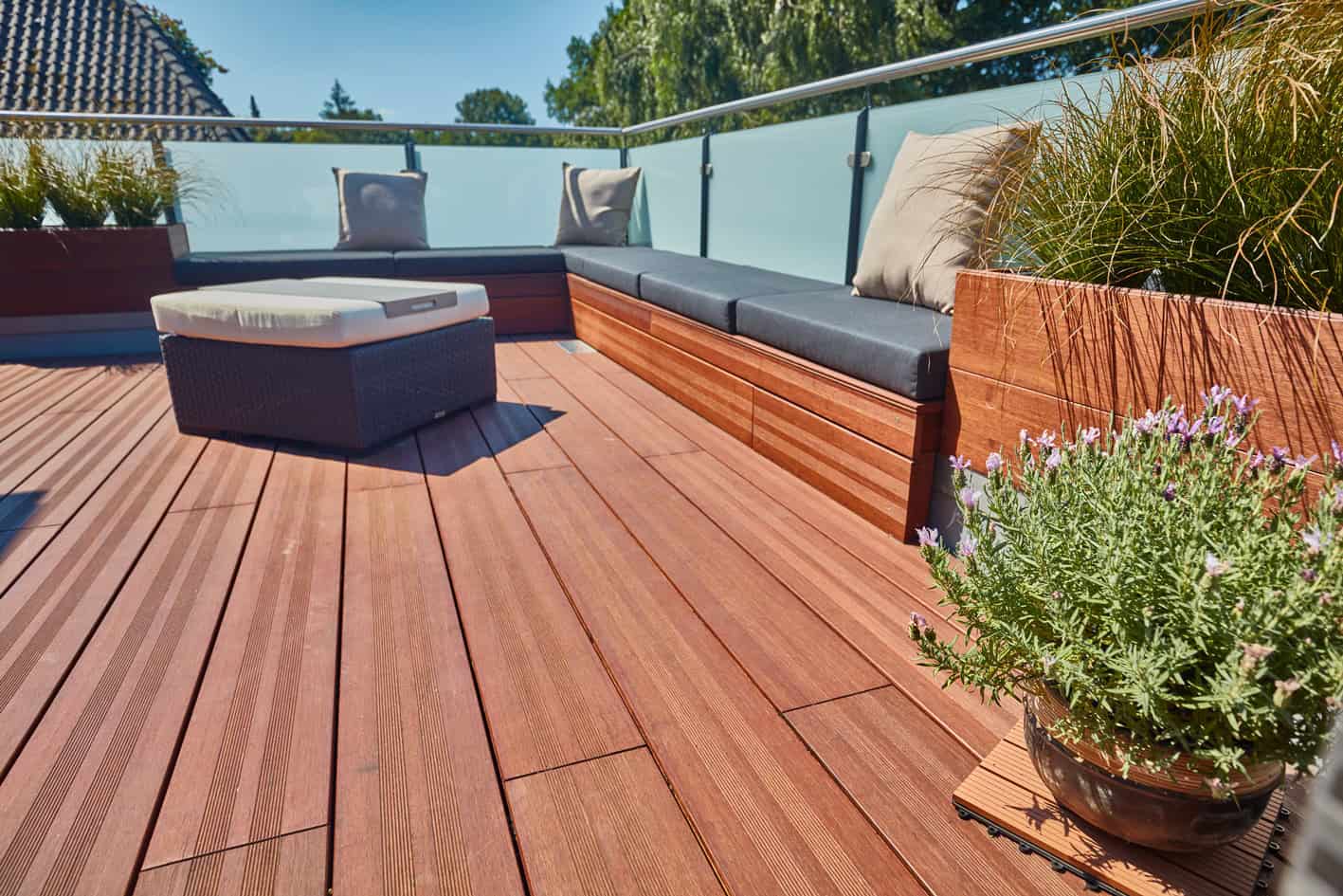 Moderner Balkon mit Bambus- und Holzterrasse, Gartenmöbel und grüne Pflanzen.