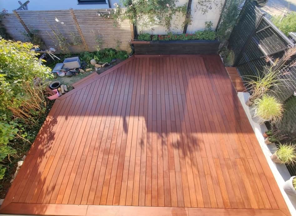 Holzterrasse im Garten mit gepflegtem Holzbelag und Pflanzen.