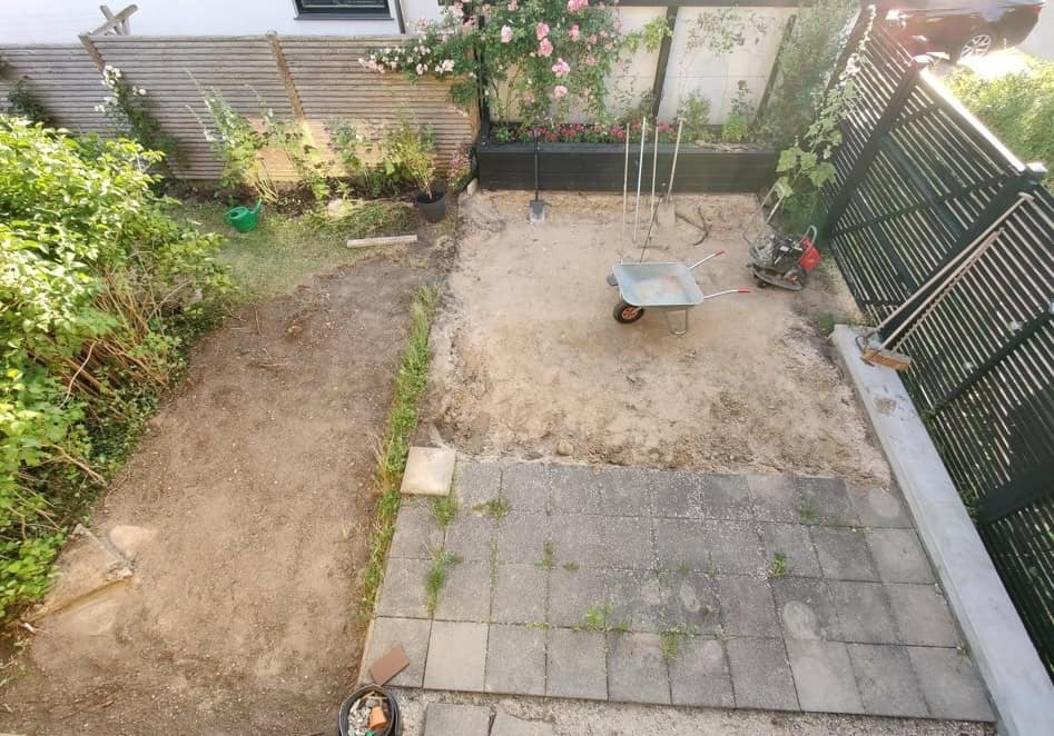 Garten im Umbau mit Pflaster, Pflanzen und Gartenwerkzeugen.