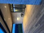 Garten-Terrasse mit Holzdecks, Glaswand und moderner Beleuchtung.